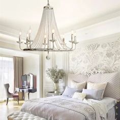 a bedroom with a chandelier hanging from the ceiling and a bed in front of it