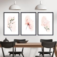 three paintings on the wall above a dining room table