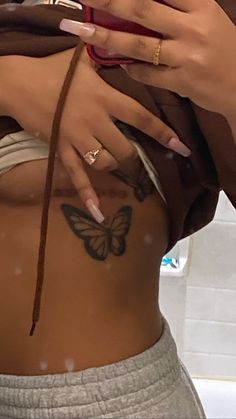 a woman with butterfly tattoos on her stomach