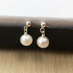 Perfect pearls!. Top quality, (AAA) beautifully matched freshwater pearl stud earrings. Simple, elegant and chic.   These are small pearls, approx 7mm near round. Shiny, blemish free, natural baroque pearls, near-round in shape - wrapped with Sterling silver and hung on  matching 'short drop' stud and scroll fittings.  Also available in 14k gold fill and rose gold fill. Perfect for a thank you gift for a loved one - any ladies in your life; friend, sister, mum, girlfriend, wife. More pearl earri Anniversary Pearl Chain Earrings, Classic Pearl Chain Dangle Earrings, Classic Drop Pearl Earrings For Everyday, Silver Dainty Pearl Earrings For Formal Occasions, Dainty Silver Pearl Earrings For Formal Occasions, Dainty Silver Pearl Earrings For Formal Events, Silver Pear-shaped Dainty Earrings, Minimalist Drop Pearl Earrings For Anniversary, Dainty Pear-shaped Silver Earrings