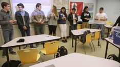 a group of people standing in front of a classroom