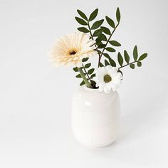 a white vase with some flowers in it