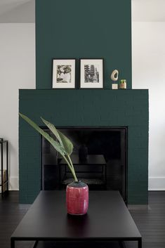 a living room with a fireplace and green walls