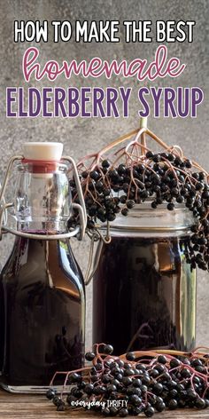 two jars filled with elderberry syrup sitting on top of a wooden table next to berries