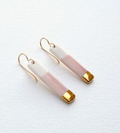 two pairs of pink and white earrings with gold accents on the earwires, against a white background