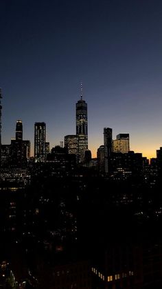 the city skyline is lit up at night, with skyscrapers in the foreground