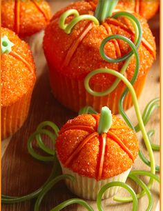 some orange cupcakes with green sprinkles on them