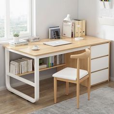 a wooden desk with a computer on top of it next to a chair and window