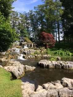 there is a small waterfall in the middle of some rocks and trees on the other side