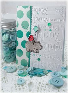 a jar filled with buttons next to a card