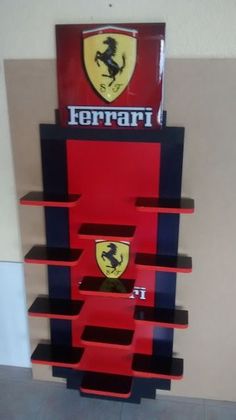 the ferrari logo is on display in front of a red and black book shelf with shelves below it