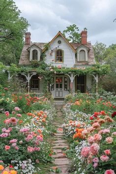 a white house surrounded by lots of flowers