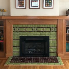 a living room with a fire place and two framed pictures on the wall above it