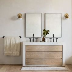 a bathroom with two sinks and mirrors on the wall