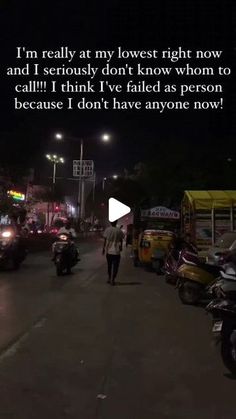 a man is walking down the street at night with his motorcyclist behind him