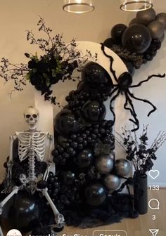 a skeleton sitting on top of a table next to balloons and flowers in vases