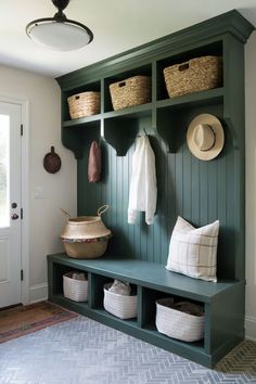 A mudroom entryway with a green-painted wall, storage cubbies, and a bench with baskets, creating a fresh and welcoming space. Mudroom Cubbies With Bench, Green Mudroom, Green Paneling, Mudroom Entryway Ideas, Entryway Cubbies, Create An Entryway, Mudroom Paint, Mudroom Cubbies, Cubby Storage Bench