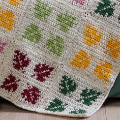 a crocheted blanket is laying on the floor