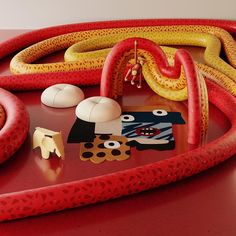 a red table topped with lots of different types of items on top of each other