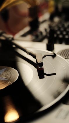 an old record player is sitting on top of a desk next to a computer keyboard