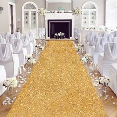 the aisle is decorated with white flowers and gold sequins for an elegant wedding