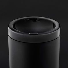 a black trash can sitting on top of a table