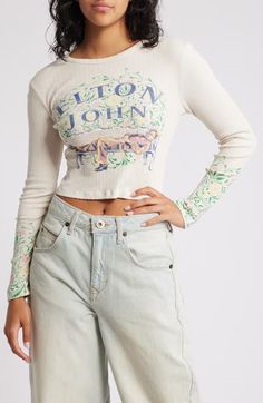 A '70s-era Elton John reclines amidst English garden blooms on this long-sleeve pointelle T-shirt. 17 1/2" length (size Medium) Crewneck Long sleeves 100% cotton Dry clean or hand wash, dry flat Made in the USA Spring Cotton Long Sleeve Top With Graphic Print, Fitted Casual Long Sleeve Top For Spring, Vintage Graphic Print Top For Spring, Spring Vintage Graphic Print Top, Spring Graphic Print Stretch Tops, Graphic Print Stretch Top For Spring, Stretch Graphic Print Tops For Spring, Trendy Long Sleeve Spring Tops, Spring Graphic Print Long Sleeve Crew Neck Top