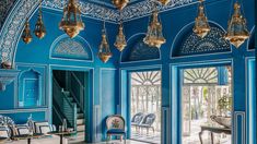 an ornate blue room with chandeliers and chairs