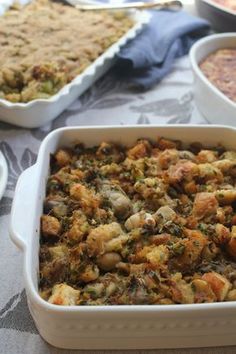 a casserole dish filled with stuffing next to other dishes