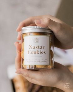 a person holding up a jar of cookies in their hands with the words nastar cookies on it