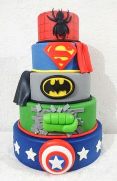 a multi layer cake decorated with batman, spiderman and captain america symbols