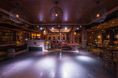 a dimly lit room with several stools and bar lights on the ceiling above it