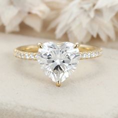 a heart shaped diamond engagement ring with pave set shoulders