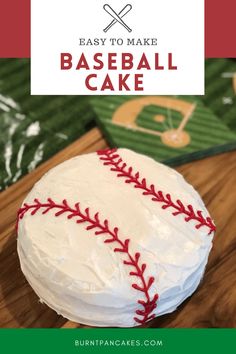 a baseball cake with white frosting and red stitches on it, sitting on top of a wooden cutting board