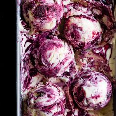 raspberry swirl rolls in a baking pan with fresh berries and blackberries on the side