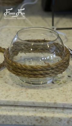 a glass bowl filled with water sitting on top of a counter next to a wire