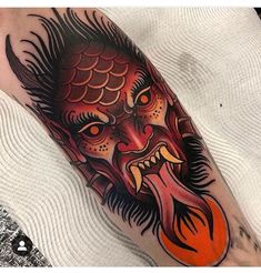 a man's leg with a tattoo on it and an orange ball in the shape of a fish