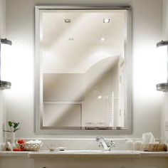 a bathroom sink under a large mirror in front of a wall mounted faucet