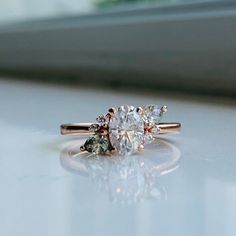 an engagement ring with three stones on the side and one stone in the middle, sitting on a window sill