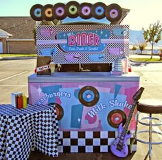 an ice cream stand with doughnuts and checkered tablecloth