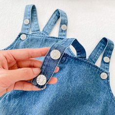 A denim bodysuit never goes out of style. Dress her up in this denim bodysuit featuring super soft denim fabric. This bodysuit includes an elastic openings at the legs and closure button straps to ensure a comfy fit perfect for any warm weather occasion. Pair with a cute denim hat or ruffle neck long sleeve on cooler days, for a complete outfit. Make your baby more lovely. Great for daily wear, birthday party, or baby photography. Material: COTTON Collar: O-Neck Item Type: Bodysuits Sleeve Lengt Denim Blue Buttoned Overalls For Spring, Denim Blue Overalls With Buttons For Spring, Spring Denim Blue Overalls With Buttons, Dark Wash Buttoned Cotton Denim Jumpsuit, Denim Blue Buttoned Overall Jumpsuit, Spring Medium Wash Overalls With Button Closure, Summer Medium Wash Denim Jumpsuit With Suspenders, Casual Solid Bodysuit With Button Closure, Cotton Jumpsuits And Rompers With Buttons In Medium Wash