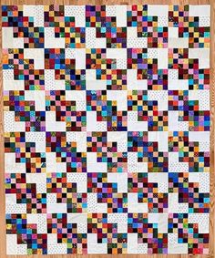 a colorful quilt is displayed on a wooden surface