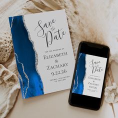 a phone next to a blue and white save the date card