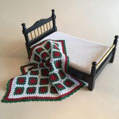 a crocheted blanket on top of a bed next to a quilted bedspread