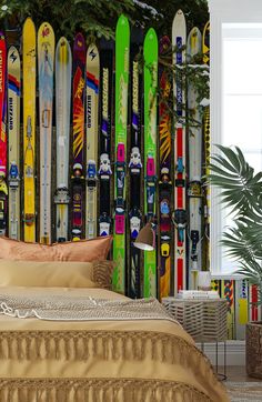 there is a bed that has many skis on the wall in front of it