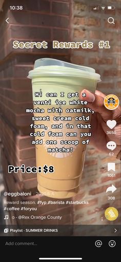 someone holding up a cup of coffee in front of a brick wall with the caption's description