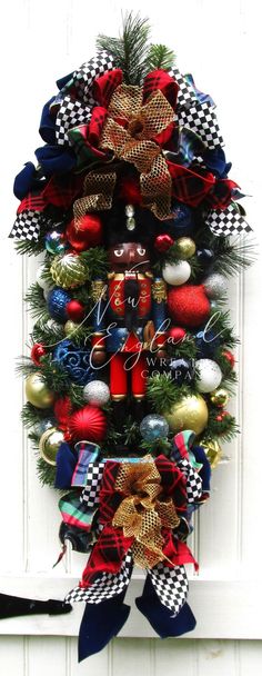 a christmas tree decorated with red, white and blue ornaments is hanging on the front door