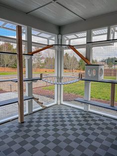 the inside of an enclosed area with hammock chairs and windows on both sides