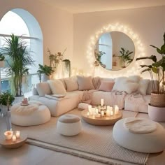 a living room filled with lots of white furniture and candles on top of the floor