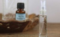 an empty glass bottle sitting on top of a wooden table next to a small container